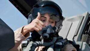 Mariam Al-Mansouri, the first female F-16 fighter pilot in the UAE Air Force, standing with her aircraft.